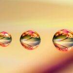 Intricate macro shot showcasing water drops reflecting vibrant floral patterns, creating a colorful and artistic image.