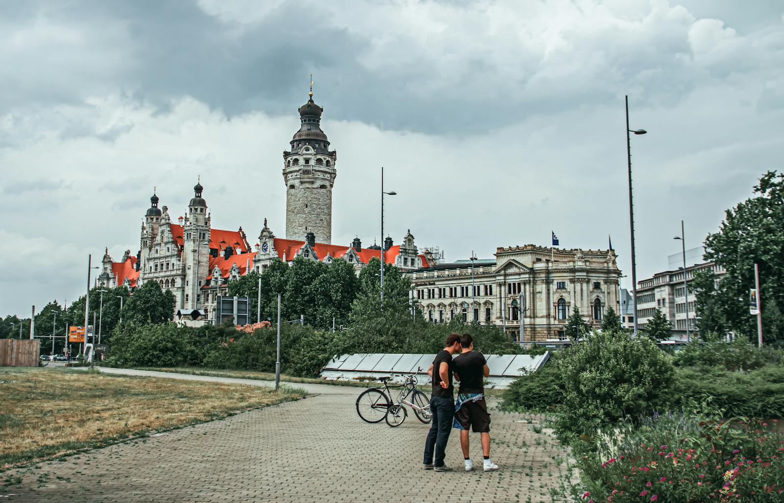 Scenic view of historical architecture with bicycles and people in Leipzig, Germany on an overcast day.
